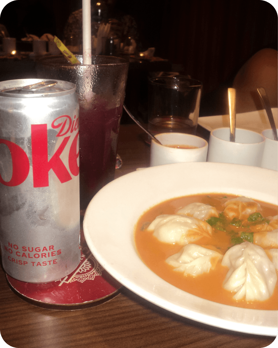 Diet Coke and momos on a restaurant table